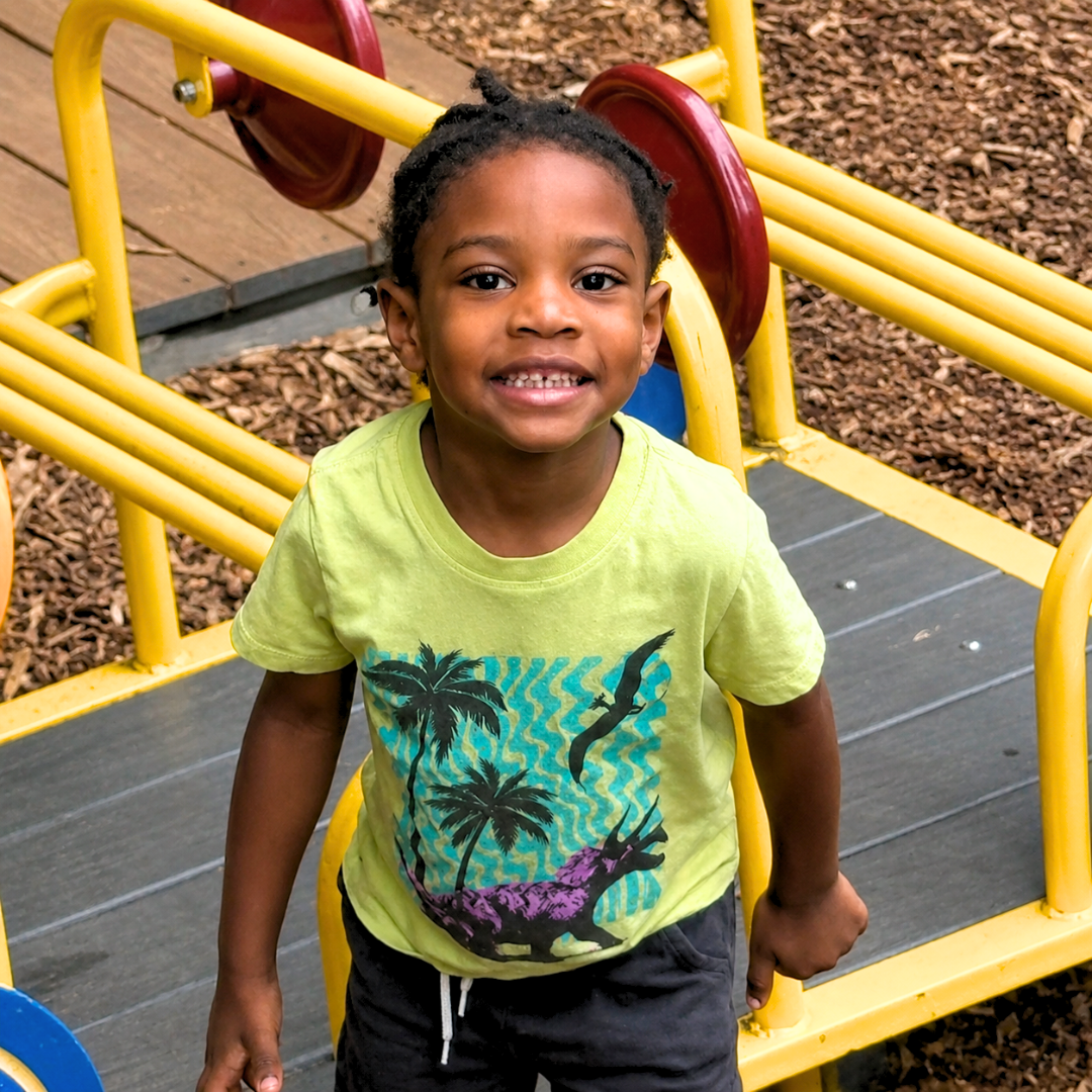 Preschooler smiling on the playground climber