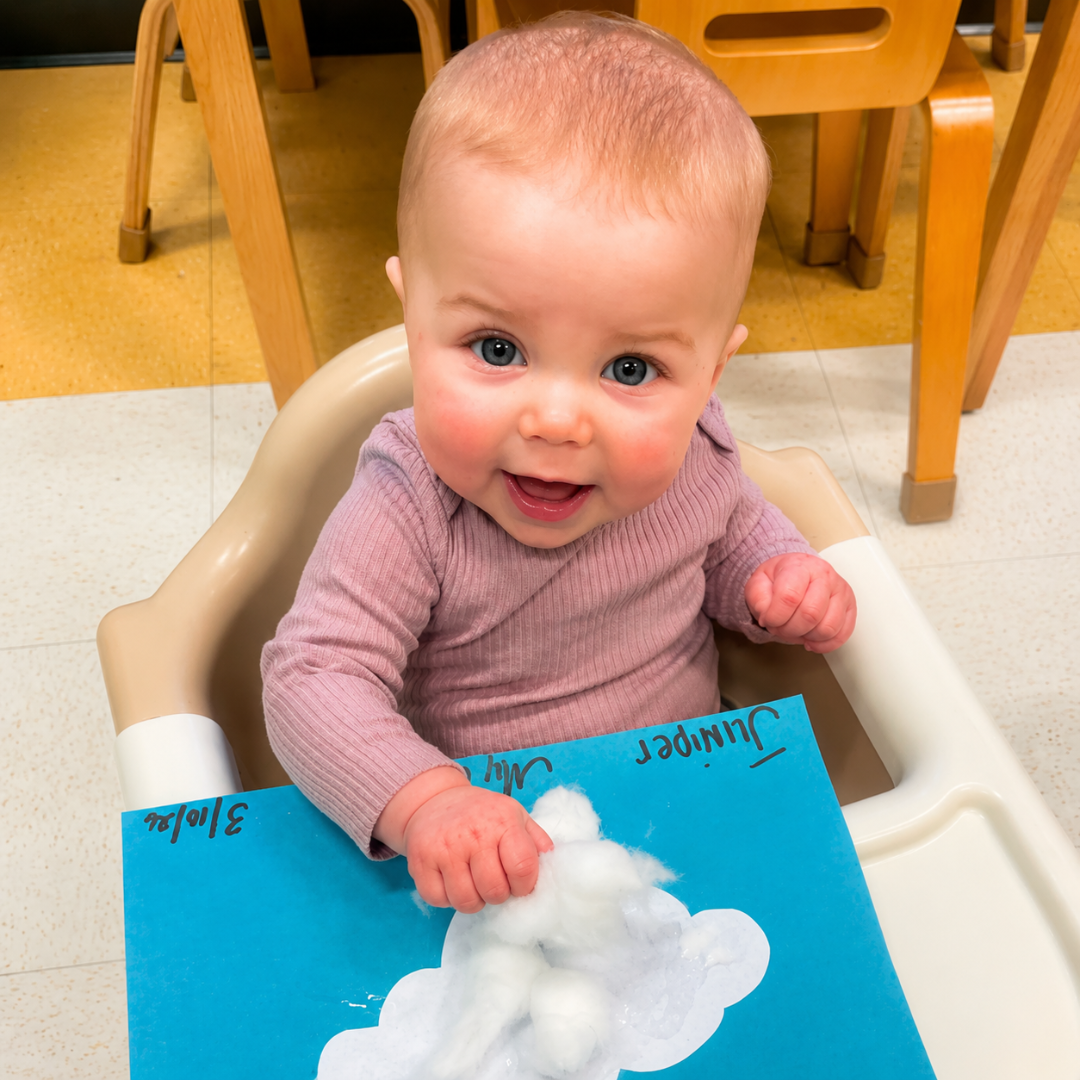Young toddler smiling during a hands-on art project